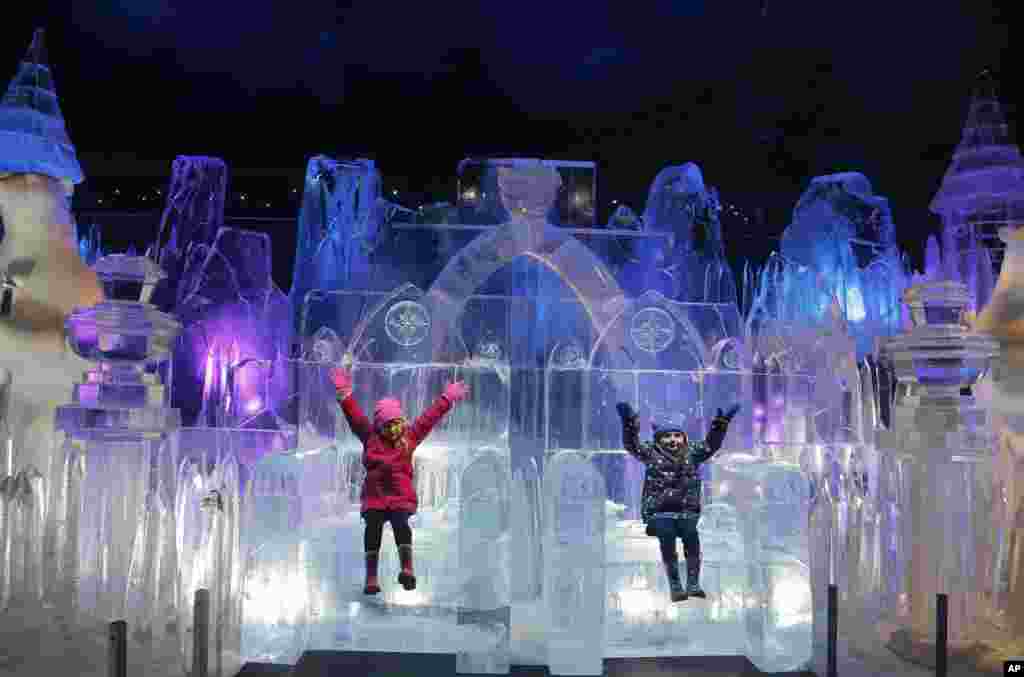 Scarlett (4 tahun) dan Zoe (3) menikmati duduk di atas patung es pada pembukaan taman Wonderland&#39;s Magical Ice Kingdom di Hyde Park, London.