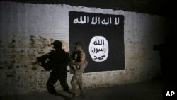 FILE - An Iraqi soldier inspects a former train tunnel displaying the the Islamic State group flag, in western Mosul, Iraq, March 1, 2017. The tunnel once served as a training camp for IS fighters.