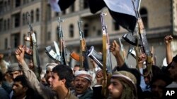 Shiite rebels, known as Houthis, hold up their weapons as they attend a protest against Saudi-led airstrikes in Sanaa, Yemen, April 10, 2015. 