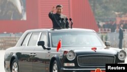 Chinese President Xi Jinping waves from a vehicle as he reviews the troops at a military parade marking the 70th founding anniversary of People's Republic of China, on its National Day in Beijing, China October 1, 2019.