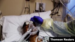 Registered nurse Alma Abad tends to COVID-19 patient Florence Bolton, 85, in the intensive care unit at Roseland Community Hospital in Chicago, Ill., Dec, 1, 2020.