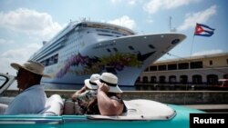 Tourists ride inside a vintage car as they pass by the Norwegian Sky cruise ship, operated by Norwegian Cruise Lines in Havana, Cuba, May 7, 2019.