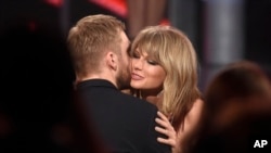 Taylor Swift (kanan) memeluk Calvin Harris setelah memenangkan penghargaan di ajang Billboard Music Awards, di Las Vegas bulan Mei lalu.