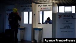 Putnik čeka rezultat testa na kovid 19 na aerodromu Šiphol u Holandiji, 29. novembra 2021. (Foto: AFP/Kenzo Tribouillard)