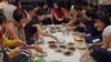 Diners pass around plates of spicy curry during a rendang tasting, an event held to educate people overseas about the popular dish and Indonesian culture, in Jakarta, Indonesia, August 4, 2012. (VOA - S. Schonhardt)