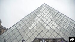 Tourists stand outside the Louvre museum, in Paris, France, March 1, 2020. 