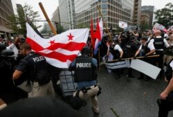 FILE - U.S. Secret Service uniformed officers tear apart barricades as they clash with anarchists and antifa counterprotesters trying to block white nationalists from departing their rally across from the White House, marking the one-year anniversary of the 2017 Charlottesville, Virginia, protests, Aug. 12, 2018.