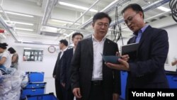 홍용표 한국 통일부 장관(왼쪽)이 10일 경기도 고양시 삼송테크노밸리에 입주한 개성공단 기업을 방문해 업체 관계자와 공장을 둘러보고 있다.