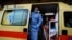 A paramedic wearing a suit to protect against coronavirus, closes the door of an ambulance at Evangelismos hospital in Athens, Nov. 12, 2020.