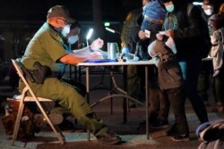 A child rests its head on a table as a U.S. Customs and Border Protection officer processes migrants who crossed into the U.S., March 24, 2021, in Roma, Texas.