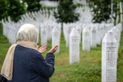 A woman prays at the memorial cemetery in Potocari, near Srebrenica, July 7, 2020. Over 8,000 Bosnian Muslims perished in 10 days of slaughter after the town was overrun by Serb forces in the closing months of the 1992-95 fratricidal war.