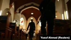 Anggota pasukan khusus polisi memegang senjata saat berjalan di dalam Katedral Makassar menjelang misa Natal, di Sulawesi Selatan, 24 Desember 2011. (Foto: REUTERS/Yusuf Ahmad)
