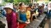 Cambodian villagers line up to cast their vote in the country's national election at a polling station at Chak Angre Leu pagoda, in Phnom Penh, Cambodia, Sunday, July 28, 2013. 