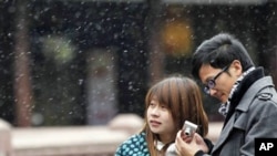 A couple visit snowy Yuyan Garden, one of the most popular tourist destinations in town, in Shanghai, China, Dec. 15, 2010.