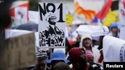 Demonstrators carry placards as they march to protest against corruption in Cape Town, South Africa, Sept. 30, 2015. 