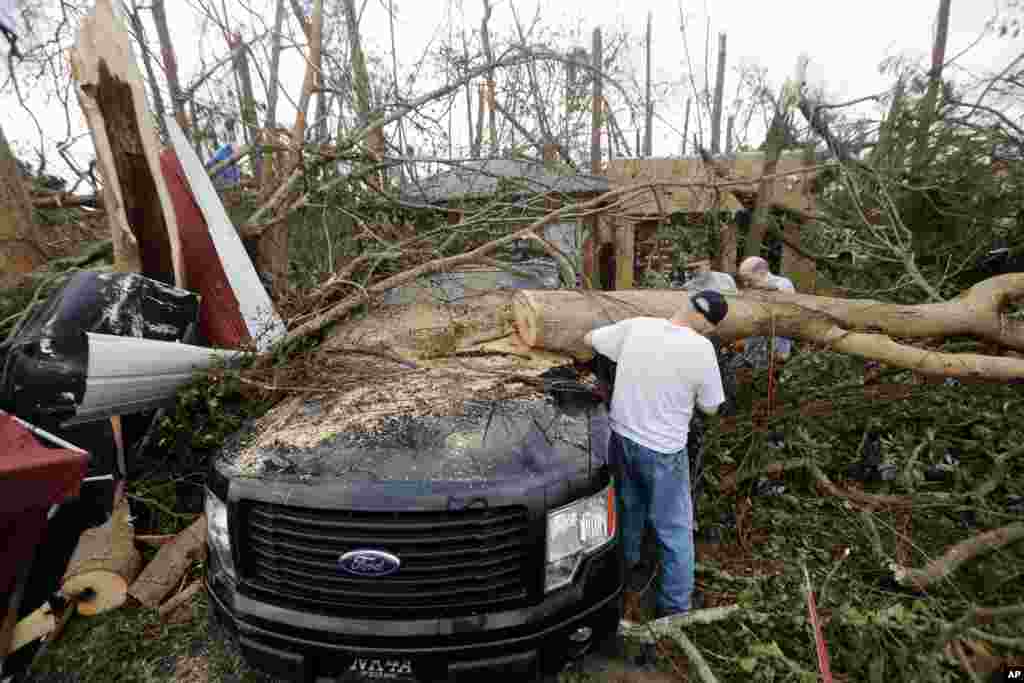 People cut away a tree that&#39;ll on a vehicle in the aftermath of Hurricane Michael in Panama City, Fla., Thursday, Oct. 11, 2018. (AP Photo/Gerald Herbert)