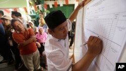 FILE - An electoral worker writes down votes during the gubernatorial election in Jakarta, Indonesia, Feb. 15, 2017. 