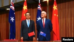 PM Australia, Malcolm Turnbull, berdiri di samping PM China, Li Keqiang, sebelum awal upacara penandatangan resmi di Gedung Parlemen Australia di Canberra tanggal 24 Maret 2017 (foto: REUTERS/David Gray)