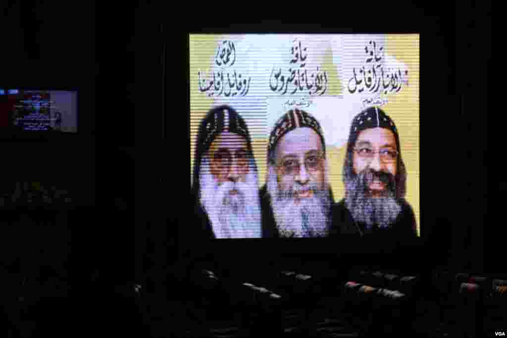 Tiga kandidat terakhir untuk pemilihan Paus ditampilkan di layar televisi di Katedral Ortodoks Saint Mark di Kairo (4/11). (VOA/Yuli Weeks)