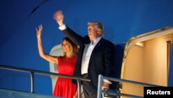 U.S. President Donald Trump and first lady Melania Trump wave from Air Force One after a "Make America Great Again" rally at Orlando Melbourne International Airport in Melbourne, Florida, Feb. 18, 2017.