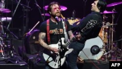 Jesse Hughes (L), the singer of US rock group Eagles of Death Metal, performs on stage at the Olympia concert hall in Paris, Feb. 16, 2016. 