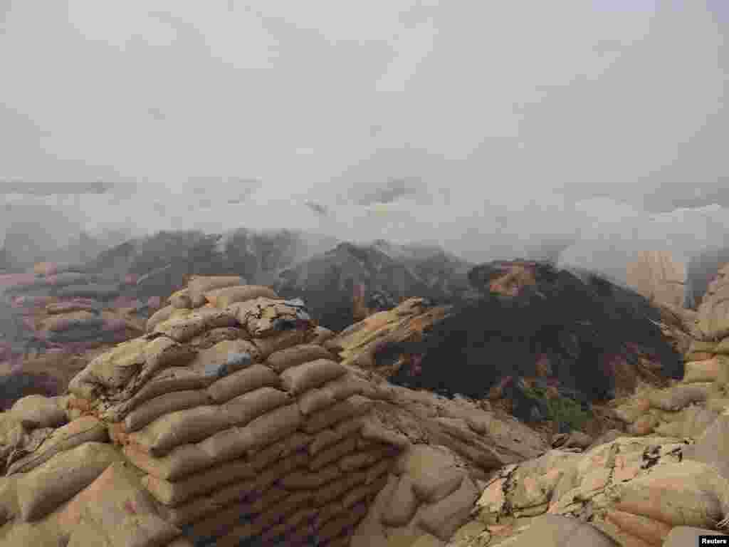 Smoke rises from damaged wheat sacks after Syrian Air Force fighter jets fired missiles at the town of Ras al-Ain, Syria, November 26, 2012. 