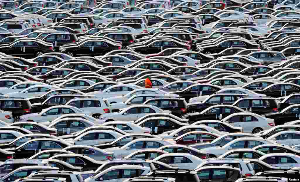 A worker walks through Mercedes cars at a shipping terminal in the harbor of Bremerhaven, Germany.