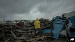 មនុស្សម្នា​ដើរ​កាត់​គំនរ​បាក់បែក​នៅ​លើ​ផ្លូវ​នៃ​ក្រុង Beira ប្រទេស​ម៉ូសំប៊ិក បន្ទាប់​ពី​ព្យុះ Idai បាន​ធ្វើ​ឲ្យ​បាក់​ដី កាលពី​ថ្ងៃទី១៦ ខែមីនា ឆ្នាំ២០១៩។