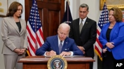 美国总统拜登在副总统哈里斯、卫生部长贝塞拉和司法部副部长莫纳科的陪同下在白宫签署一项行政命令，保护女性寻求包括堕胎在内的生育保健服务。(2022年7月8日)