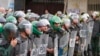 Cambodian riot policemen line up as supporters of opposition parties gather for demonstrations in Phnom Penh, Cambodia