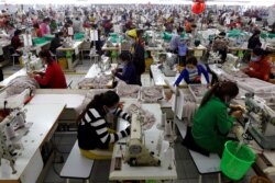 FILE - Employees work at a factory supplier of the H&M brand in Kandal province, Cambodia, Dec. 12, 2018.