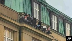 Studenti za vreme pucnjave traže zaklon na simsu zgrade Filozofskog fakulteta na Karlovom univerzitetu u Pragu, 21. decembra 2023. (Foto: AP/X/elirozic)