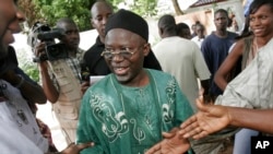 FILE - Opposition presidential candidate Ousainou Darboe greets supporters after casting his vote in Serrekunda, Gambia, Sept. 22, 2006. 
