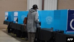 FILE - A Georgia voter marks a ballot during the first day of early voting in the U.S. Senate runoffs at the Gwinnett County Fairgrounds, in Atlanta, Georgia, Dec. 14, 2020.
