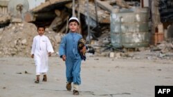 Falastinlik bola G'azo Sektorining Xon-Yunus shahrida Qurbon hayiti namoziga ketyapti, 16-iyun, 2024-yil