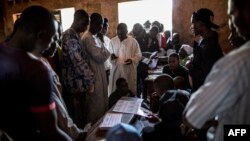 Voters queue to collect their cards at the polling station at the Koudoukou school in the flashpoint PK5 district in Bangui on Dec.14, 2015, where voting operations for the Constitutional Referendum are still underway.