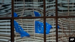 Refleksi Bendera Uni Eropa berkibar di kaca gedung Dewan Eropa di Brussels, 19 Desember 2020. (Foto: dok).
