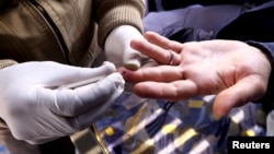 A nurse takes blood from a man for a free HIV test on a bus in Tehran, Dec. 16, 2015. In Europe, for the first time since the early 2000s, syphilis is more common in some countries than new cases of HIV, health experts said Friday.