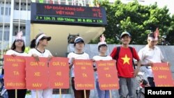 Students hold placards in a protest against a gasoline price hike in front of Petrolimex, in Hanoi, September 16, 2012.