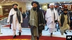 FILE - Deputy chief for Taliban political affairs, Mullah Abdul Ghani Baradar, center, arrives with other members of the Taliban delegation for a peace conference in Moscow, Russia, March 18, 2021.