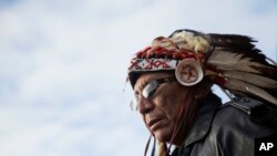 Chief Arvol Looking Horse, a spiritual leader of the Great Sioux Nation puts on his headdress for an interfaith ceremony at the Oceti Sakowin camp where people have gathered to protest the Dakota Access oil pipeline in Cannon Ball, N.D. As cities and towns host July 4th parades and fireworks shows, some minority residents are expressing mixed feelings about the holiday used to reaffirm the country's founding based on equality and civil liberties. 