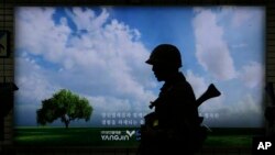 A South Korean army soldier passes by an advertising board during an anti-terror drill as part of Ulchi Freedom Guardian exercise, at Sadang Subway Station in Seoul, South Korea, Aug. 19, 2015. 