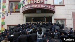 FILE - Riot police block the entrance of a pro-Kurdish People's Democratic Party (HDP) office in order to prevent party members from going out for a demonstration in the southeastern city of Diyarbakir, Turkey, Jan. 21, 2018. 