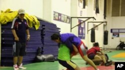 Cambodian Wrestler Chov Sotheara Trains with Male Wrestler while North Korean Coach Watches, February 2012, Phenom Penh, Cambodia (VOA - Daniel Schearf)