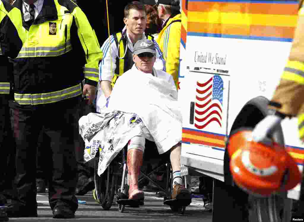 Seorang pelari di atas kursi roda dibawa dari tenda perawatan menyusul ledakan pada Marathon Boston ke-117 di Boston, Massachusetts (15/4).