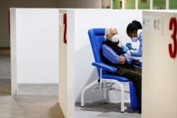 A man receives a dose of the Moderna vaccine against the coronavirus, at the Music Auditorium in Rome, Italy, March 17, 2021.