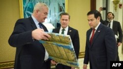 ইউক্রেনের পররাষ্ট্রমন্ত্রী আন্দ্রি সিবিহা সৌদি আরবের জেদ্দায় যুক্তরাষ্ট্রের পররাষ্ট্রমন্ত্রী মার্কো রুবিও এবং জাতীয় নিরাপত্তা উপদেষ্টা মাইক ওয়াল্টজের সাথে কথা বলার সময় একটি ধর্মীয় চিহ্ন হাতে নিয়ে আছেন। ( ১১ মার্চ, ২০২৫)