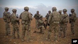 FILE - Photo released by the U.S. Army shows U.S. soldiers gathering for a brief during a combined joint patrol rehearsal in Manbij, Syria, Nov. 7, 2018. 