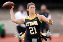 Ottawa quarterback Madysen Carrera passes to a teammate while pressured by a Midland defender during an NAIA flag football game in Ottawa, Kan., March 26, 2021.