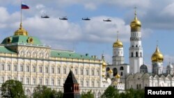 Russian military helicopters fly in formation with the Kremlin and the Ivan the Great Bell Tower seen in the foreground, in central Moscow May 3, 2014.